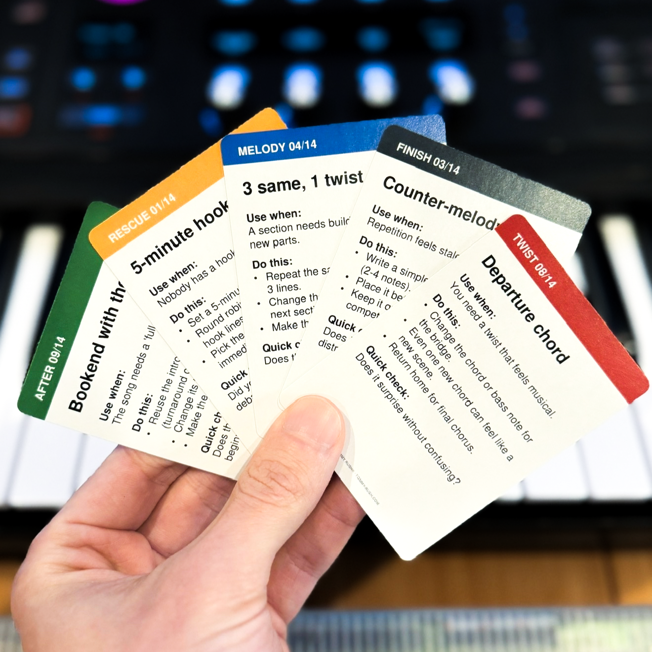 Session Cards held in front of studio equipment — showing cards from multiple categories